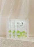 Beauty of Joseon Centella Asiatica Calming Mask 25ml x 10ea in white packets with green centella leaf illustrations, arranged on soft beige surface